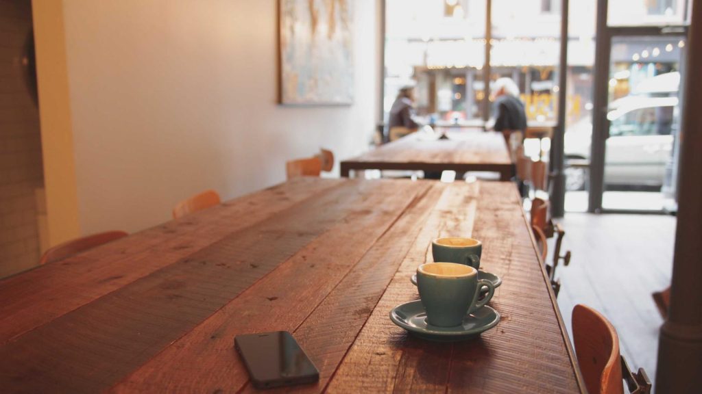 Long wooden table in a bright cafe